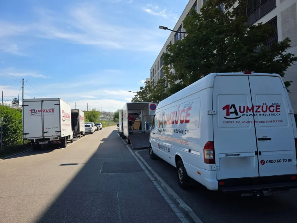 Weisser Sprinter-Lieferwagen der 1A Umzüge GmbH am Strassenrand, dahinter weitere Lieferwagen